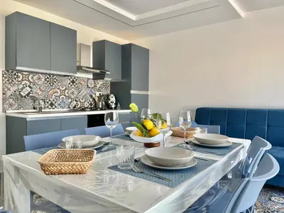 a dining room with a table with plates and wine glasses at M'AMA apartment 2 in Ficarazzi