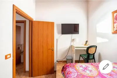 a bedroom with a bed and a desk with a chair at home indipendenza 2 in Palermo