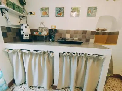 a kitchen with a counter with curtains on it at Le due Marie in Palermo