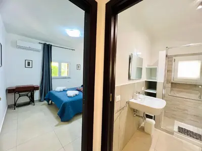 a bathroom with a bed and a sink and a mirror at L'Angolo del Saraceno in Carini