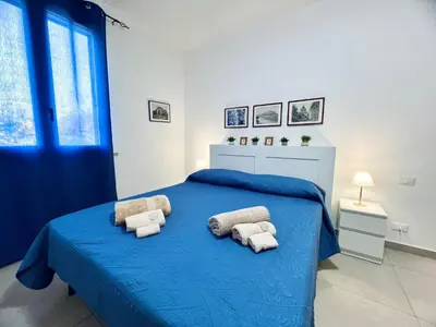 a bedroom with a blue bed with towels on it at L'Angolo del Saraceno in Carini
