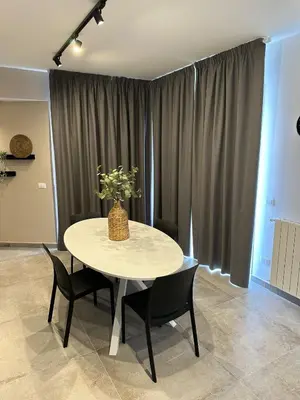 a table with chairs and a vase of flowers on it at King's house apartments in Palermo