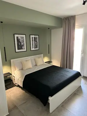 a bedroom with a black and white bed and a window at King's house apartments in Palermo