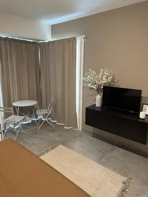 a living room with a television and a table and chairs at King's house apartments in Palermo
