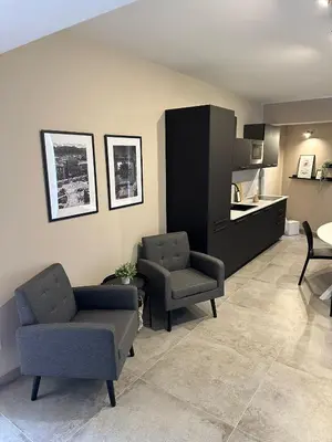 a living room with a couch and chairs and a kitchen at King's house apartments in Palermo