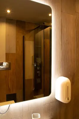 a mirror on a bathroom wall with a shower at Spera Luxury in Monreale
