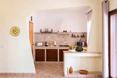 a kitchen with a large open doorway into a kitchen at Exclusive Palm House near the beach in Alcamo