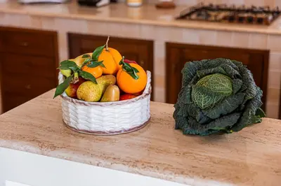 a basket of fruit and vegetables on a counter at Exclusive Palm House near the beach in Alcamo
