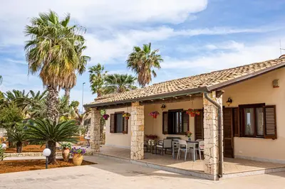 a house with palm trees and a patio at Exclusive Palm House near the beach in Alcamo