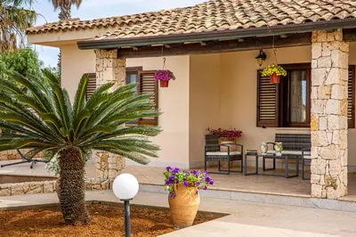 a house with a palm tree and a patio at Exclusive Palm House near the beach in Alcamo