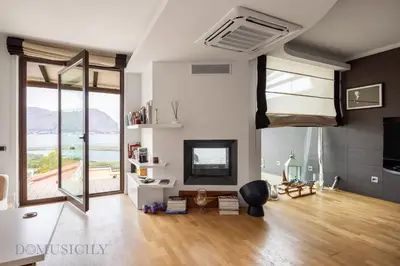 a living room with white walls and wooden floors and windows at Villa Maurino by DomuSicily in Mondello