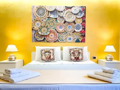 a bedroom with a bed with two pillows and a painting on the wall at Al Politeama Rooms B&B in Palermo