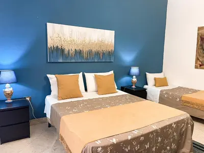 a bedroom with two beds and a blue wall at Al Politeama Rooms B&B in Palermo