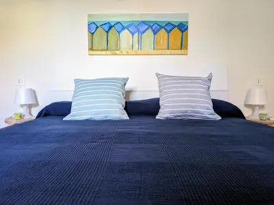 a bedroom with a blue bed with two pillows at Mondello Villetta Giusi in Mondello