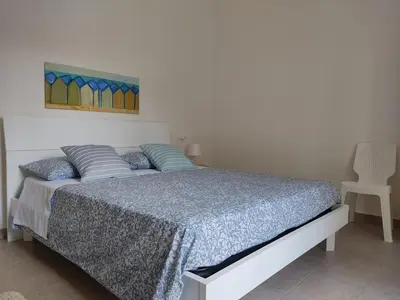 a bedroom with a bed with a painting on the wall at Mondello Villetta Giusi in Mondello