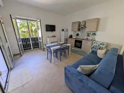 a living room with a blue couch and a table at Mondello Villetta Giusi in Mondello