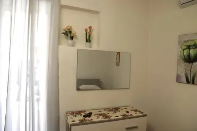 a bathroom with a mirror and a stool with flowers at Lo scarrozzo room in Palermo