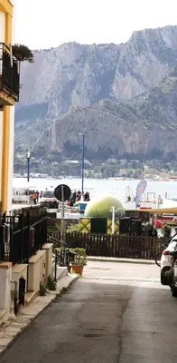 a marina with boats in the water and a mountain at Lo scarrozzo room in Palermo
