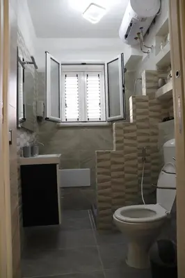 a bathroom with a toilet and a sink and a window at Lo scarrozzo room in Palermo