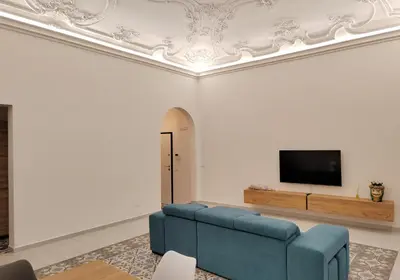 a living room with a couch and a tv on a wall at Ciuririvù in Palermo