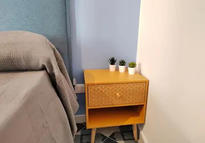 a nightstand with two plants on it next to a bed at Ciuririvù in Palermo