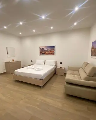 a large bedroom with a bed and a couch at Casetta al Molo Trapezoidale in Palermo