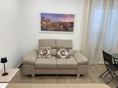 a living room with a couch and a painting on the wall at Casetta al Molo Trapezoidale in Palermo