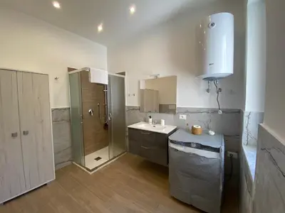 a kitchen with a wooden table and chairs at Casetta al Molo Trapezoidale in Palermo