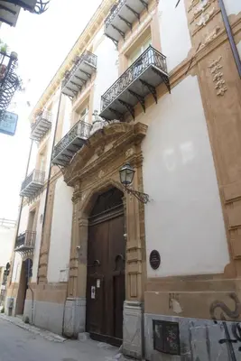 a building with a wooden door and a balcony at Piano Alloro in Palermo
