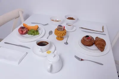 a table with plates of food and a cup of coffee at Piano Alloro in Palermo