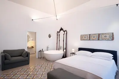 a bedroom with a bed and a bath tub and a chair at Piano Alloro in Palermo