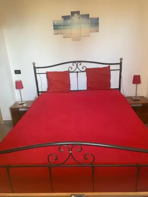 a bedroom with a red bed with red pillows at Casa al mare in Lascari