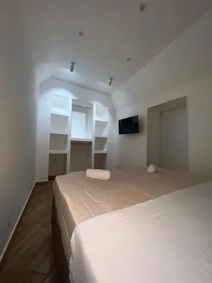 a bedroom with two beds and a tv on the wall at Incanto di luna Apartment in Palermo