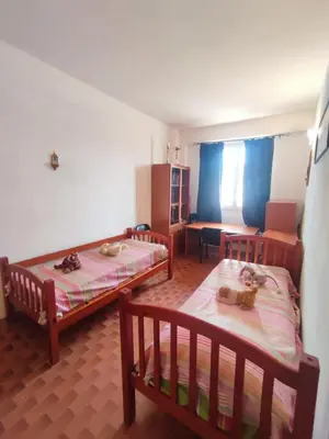 a room with two beds and a table and a chair at Balestrate holiday home 70 Mq in Balestrate