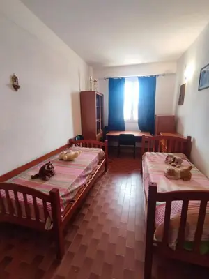 a room with two beds and a living room with at Balestrate holiday home 70 Mq in Balestrate