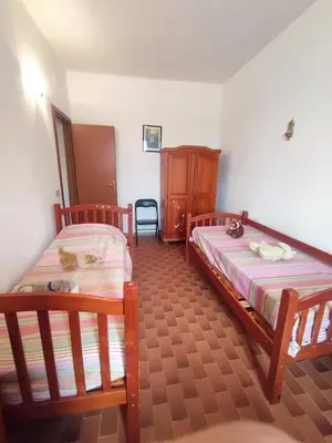 a bedroom with two beds and a wooden cabinet at Balestrate holiday home 70 Mq in Balestrate