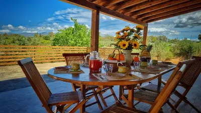 a wooden table with flowers and drinks on a patio at Villa Ginevra in Balestrate
