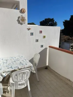 a patio with a table and chairs on a wall at Aurora e Andrea San Vito lo Capo in San Vito lo Capo