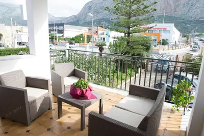 a balcony with chairs and a table with a view of a city at Casa Vacanze Ines in Carini