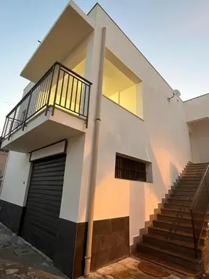 a white house with a staircase and a balcony at Casa Vacanze Ines in Carini