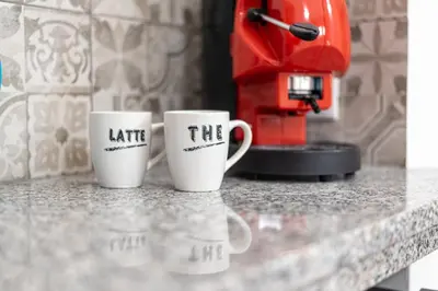 two coffee mugs with the words hate sitting on a counter at Quattro Canti rooms in Palermo
