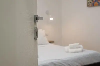 a bedroom with a bed with white sheets at Quattro Canti rooms in Palermo