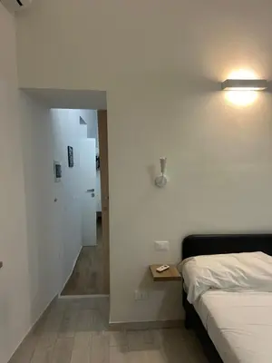 a bedroom with a bed and a table and a hallway at Quattro Canti rooms in Palermo