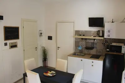 a kitchen with a table and a small kitchen with a table and chairs at Casa di DaFe-Casa Vacanze in Castellammare del Golfo