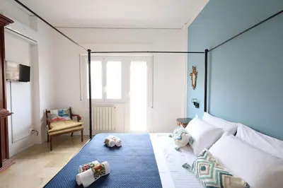 a bedroom with a large bed with a blue wall at Studio Florio in Palermo