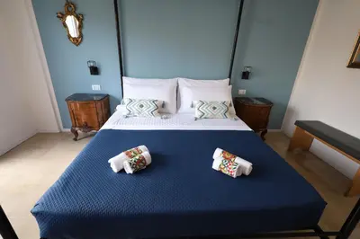 a bedroom with a blue bed with two pillows on it at Studio Florio in Palermo