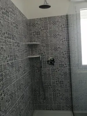 a bathroom with a shower with a tile wall at Studio Florio in Palermo