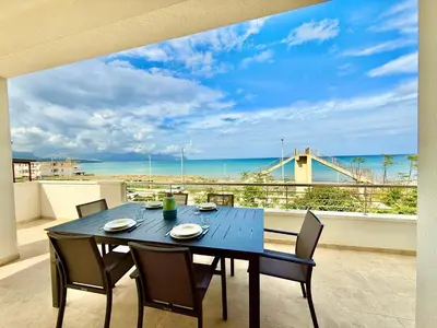 a blue table with chairs and a view of the ocean at Brezza Marina Apartment, 50 mt dalla spiaggia in Alcamo
