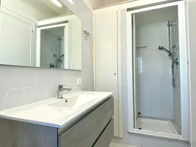 a white bathroom with a sink and a shower at Brezza Marina Apartment, 50 mt dalla spiaggia in Alcamo