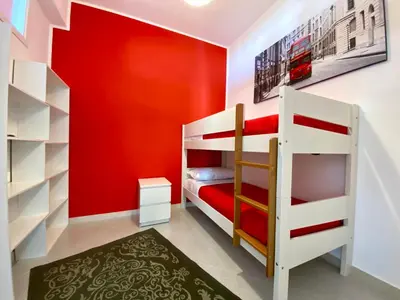 a childs room with red walls and bunk beds at Brezza Marina Apartment, 50 mt dalla spiaggia in Alcamo